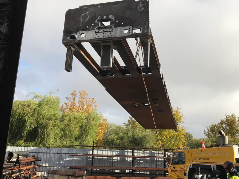 A fabricated steel frame being lifted by crane in the Hapco yard
